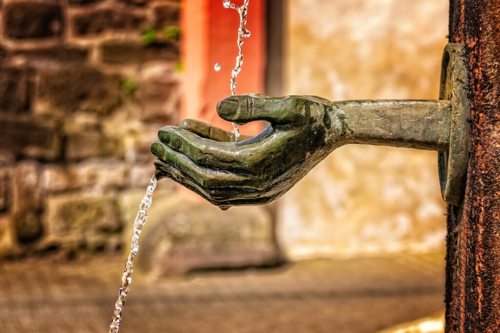 水流を受け止める広場の銅像の手