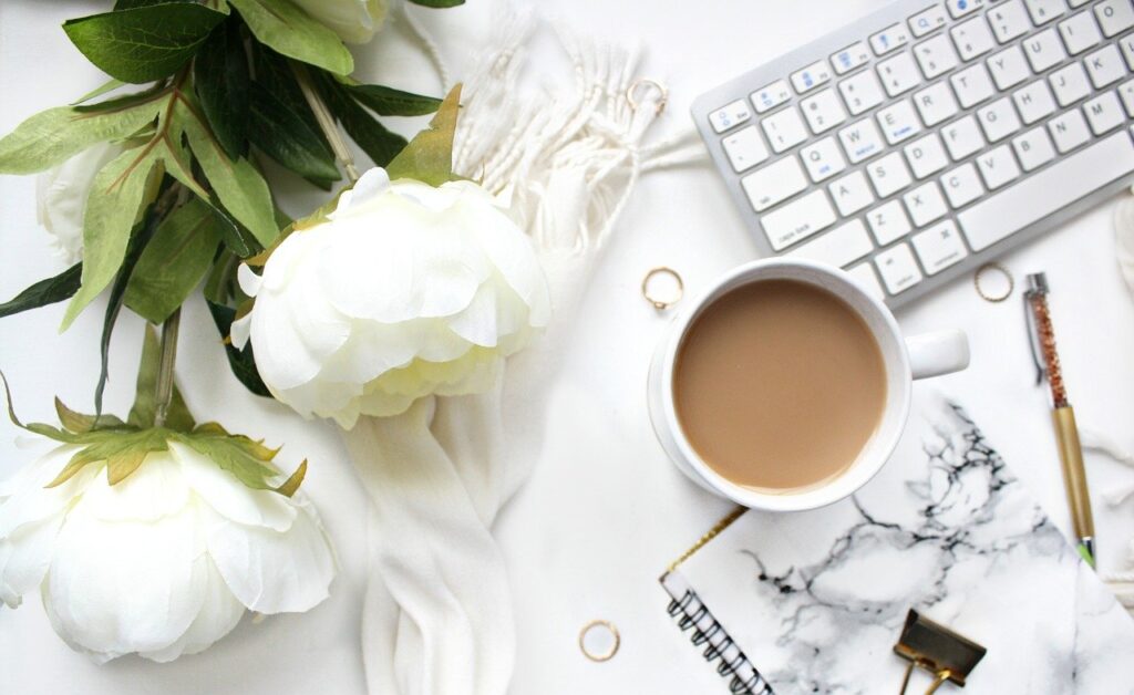 白い花束とコーヒーとパソコン