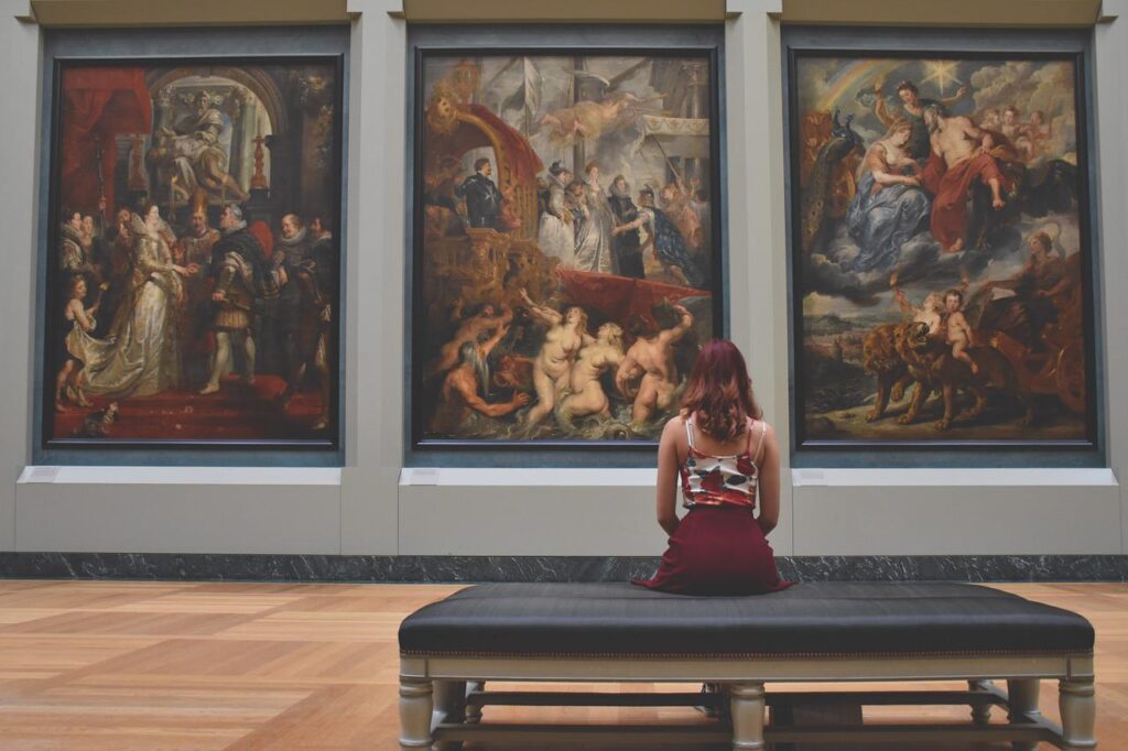 歴史ある絵画を美術館で眺める女性